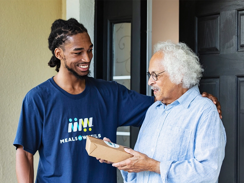 volunteer-with-senior-holding-a-meal